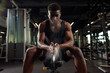 © Богдан Маліцький - sporty african american man trains in dark gym and rubs his hands with magnesia, young guy makes clap