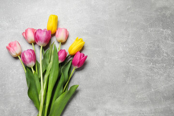 Wall Mural - Beautiful colorful tulip flowers on grey table, flat lay. Space for text