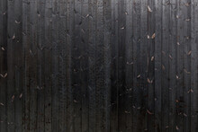 Vertical Black Dark Burned Wood Vertical Linear Pattern Facade. 