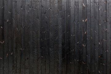 Vertical black dark burned wood vertical linear pattern facade. 