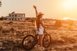 © svetograph - Woman travel bike. Happy woman cyclist sitting on her bike, enjoying the beautiful mountain and sea landscape, signifying the idea of an adventurous bike ride.