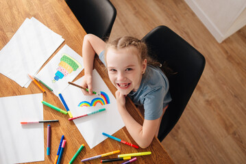 The cute Girl draws and smiles. Children draw in their free time