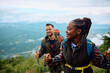 © Drazen - Black woman and her boyfriend hiking in mountains.