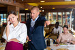 © JackF - Angry man client of restaurant yelling at young waitress chasing her away