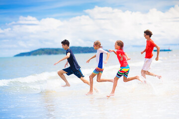 Wall Mural - Kids play on tropical beach. Sand and water toy.