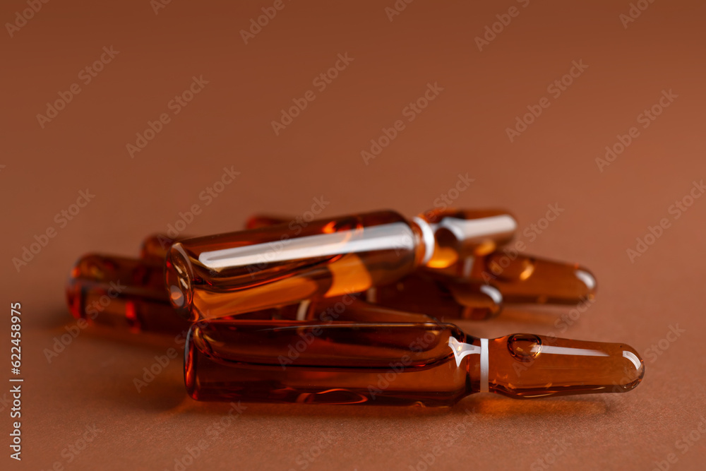 Many ampules on brown background, closeup