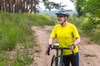 © photosaint - bearded man cyclist in yellow clothes rides a bike on a road in nature. sports, hobbies and entertainment for health