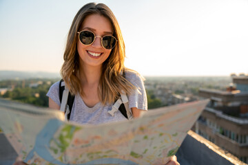 Wall Mural - traveler girl searching right direction on map, travel, freedom and active lifestyle concept