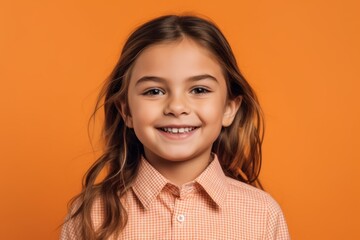 Poster - portrait of smiling little girl looking at camera isolated on orange background