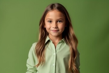 portrait of a smiling little girl in a green shirt on a green background