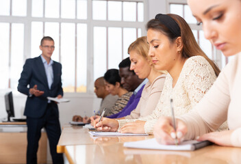 Canvas Print - Portrait of confident woman sitting in class working during group business training