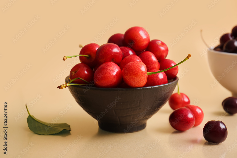 Bowl sweet cherries on beige background