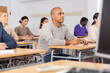 © JackF - Portrait of confident man sitting in class working during group business training