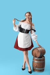 Wall Mural - Beautiful Octoberfest waitress with barrels of beer on blue background