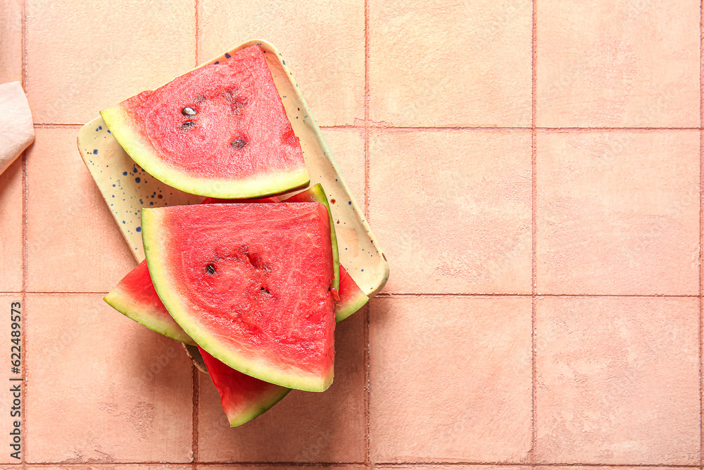 Pieces of fresh watermelon on pink tile table