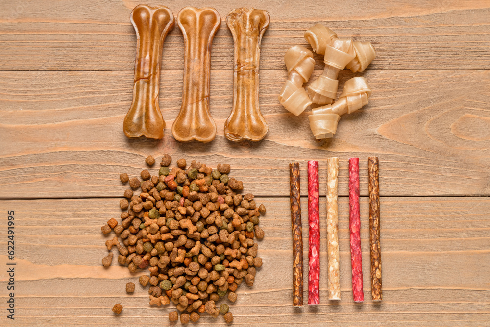 Composition with different dog treats on wooden background