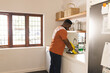 © Wavebreak Media - Focused african american man with towel on arm washing dishes in kitchen