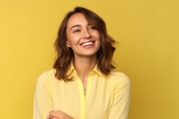 Wall Mural - Portrait of beautiful young woman in yellow shirt on yellow background.