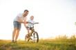 © Serhii - father's day. Dad and son playing together outdoors on a summer. Happy family, father, son at sunset.