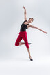 © danmorgan12 - Ballet Sport Ideas. Contemporary Ballet of Flexible Athletic Man Posing in Red Tights in Dance Pose With Hands Lifted in Studio on White.