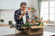 © PRPicturesProduction - The retired Asian man enjoyed the convenience of online shopping as he unpacked a carton box filled with healthy vegetable ingredients on his dining table.