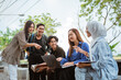 © Odua Images - Group of young university students work together on an assignment using a laptop while sitting at an outdoor cafe