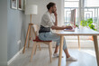 © DimaBerlin - Focused male freelancer wearing lumbar brace sitting at table using computer, young man use orthopedic corset belt while working remotely with herniated disc. Work from home and back pain