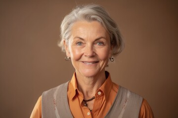 Wall Mural - Portrait of a smiling senior woman on a beige background.