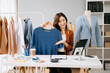 © Nuttapong punna - Fashion blogger concept, Young Asian women selling clothes on video streaming.Startup small business SME, using smartphone or tablet taking receive and checking.