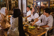 © Odua Images - Muslim woman wearing hijab and Muslim man joking while breaking fast with friends at outdoor cafe