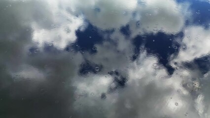 Wall Mural - aerial top view of sky with clouds reflection in water of lake, rings of rain drops, abstract backgr