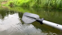 Close-up Of Plastic Paddle Over Water On River In Summer.