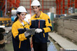 © Nassorn - Latino industrial engineer in white helmet and safety jacket work in heavy metal engineering factory. Technician worker team using tablet computer control metalwork in manufacturing facility, portrait