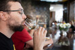 Close-up of a man at a champagne tasting. He tastes a sip from a glass of champagne. Mockup, Selective Focus. celebration, taste, alcohol. Copy space. Sommeliers tasting white wine at degustation