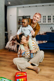 Fototapeta Nowy Jork - Mature lesbian couple playing with their adopted son