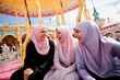 A group of young muslim women wearing headscarves having fun together at the fair