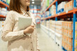 © Patcharanan - Warehouse worker hands holding tablet check stock on tall shelves in warehouse storage. Asian woman auditor or staff work looking up stock taking inventory in cargo store. Owner start up business.