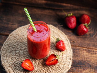Wall Mural - Strawberry smoothie on a wooden table on a knitted napkin, ripe berries. summer dessert