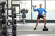 © Ljupco Smokovski - Full length portrait of a male fitness trainer exercising step aerobic with a dumbbell at the gym