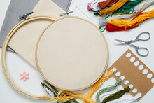 Embroidery Set Fot Stitching. Beige Cotton Cloth In Embroidery Hoop On White Background With Fabric, Colorful Threads, Scissors And Needls. Indoor Hobby Concept With Copy Space, Top View