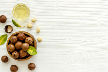Wall Mural - Macadamia nuts oil with raw shelled nuts, top view