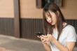 © Keyframe's - Adult woman asian texting on mobile phone with smiling face in holiday. Copy space.
