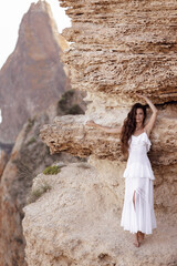 Canvas Print - beautiful woman with dark hair in elegant white dress posing in amazing nature place,