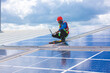 © chokniti - Engineer technician using laptop checking and operating system on rooftop of solar cell farm power plant, Renewable energy source for electricity and power, Solar cell maintenance concept