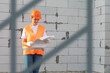 A woman in a construction uniform is studying a project.