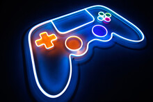Joystick Or Gamepad, Neon Sign On The Background Of The Wall. The Concept Of Computer Games.