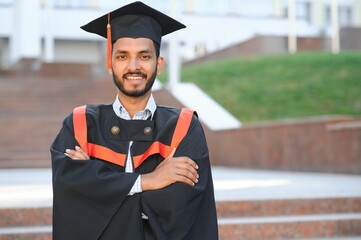 Wall Mural - Portrait of indian handsome male graduate in graduation robe.