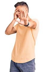 Wall Mural - Young handsome man wearing casual clothes covering eyes with hands and doing stop gesture with sad and fear expression. embarrassed and negative concept.