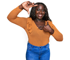 Canvas Print - Young african woman wearing casual clothes smiling making frame with hands and fingers with happy face. creativity and photography concept.