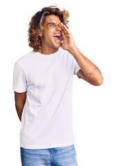 Wall Mural - Young hispanic man wearing casual white tshirt shouting and screaming loud to side with hand on mouth. communication concept.